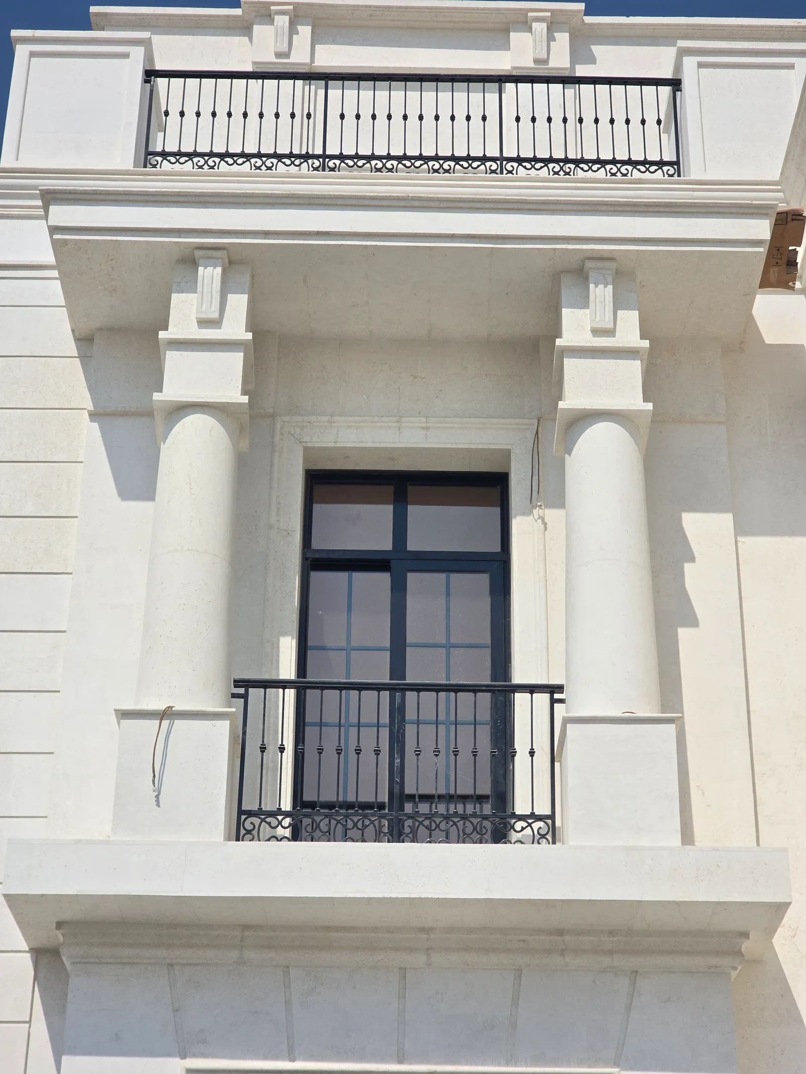 Carved stone columns and balcony on a classical villa facade in Ain Khaled, Doha, by Auckland